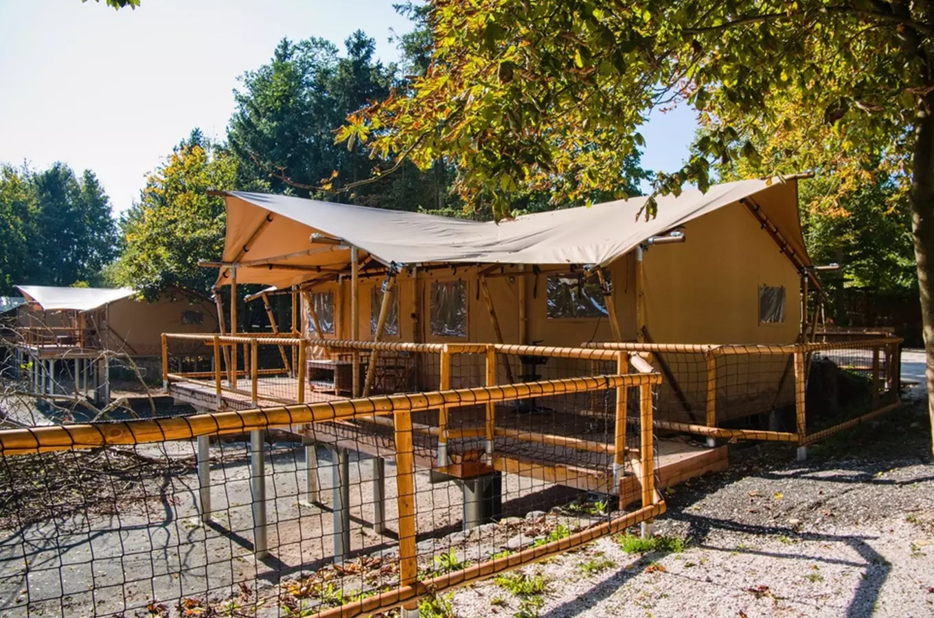 Glampinková chata s dřevěnou terasou v přírodě pro ubytování u zoo