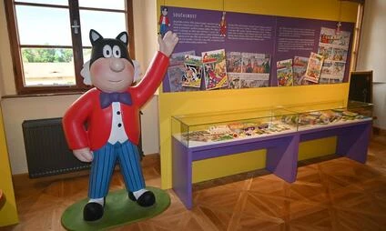 Kartoonská socha kočky v expozici muzea nebo zoologické zahrady.
